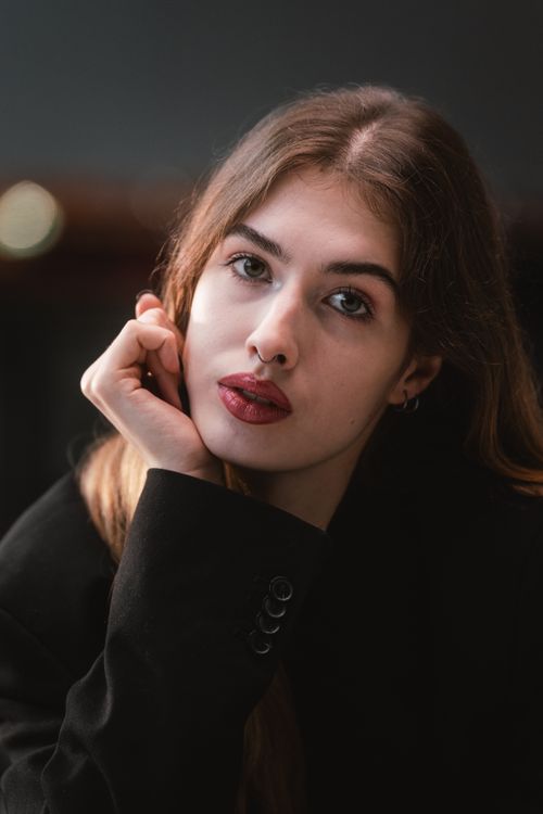 Free Artistic portrait of a young woman with a thoughtful gaze, set in a minimalist style. Stock Photo