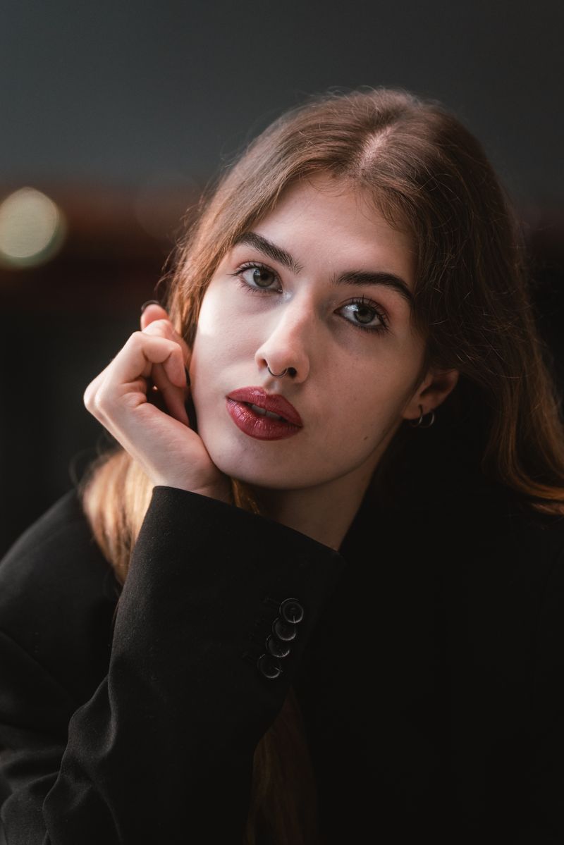 Artistic portrait of a young woman with a thoughtful gaze, set in a minimalist style.