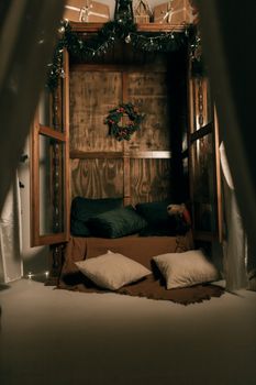 Warm indoor space decorated for Christmas with a wreath and cushions.