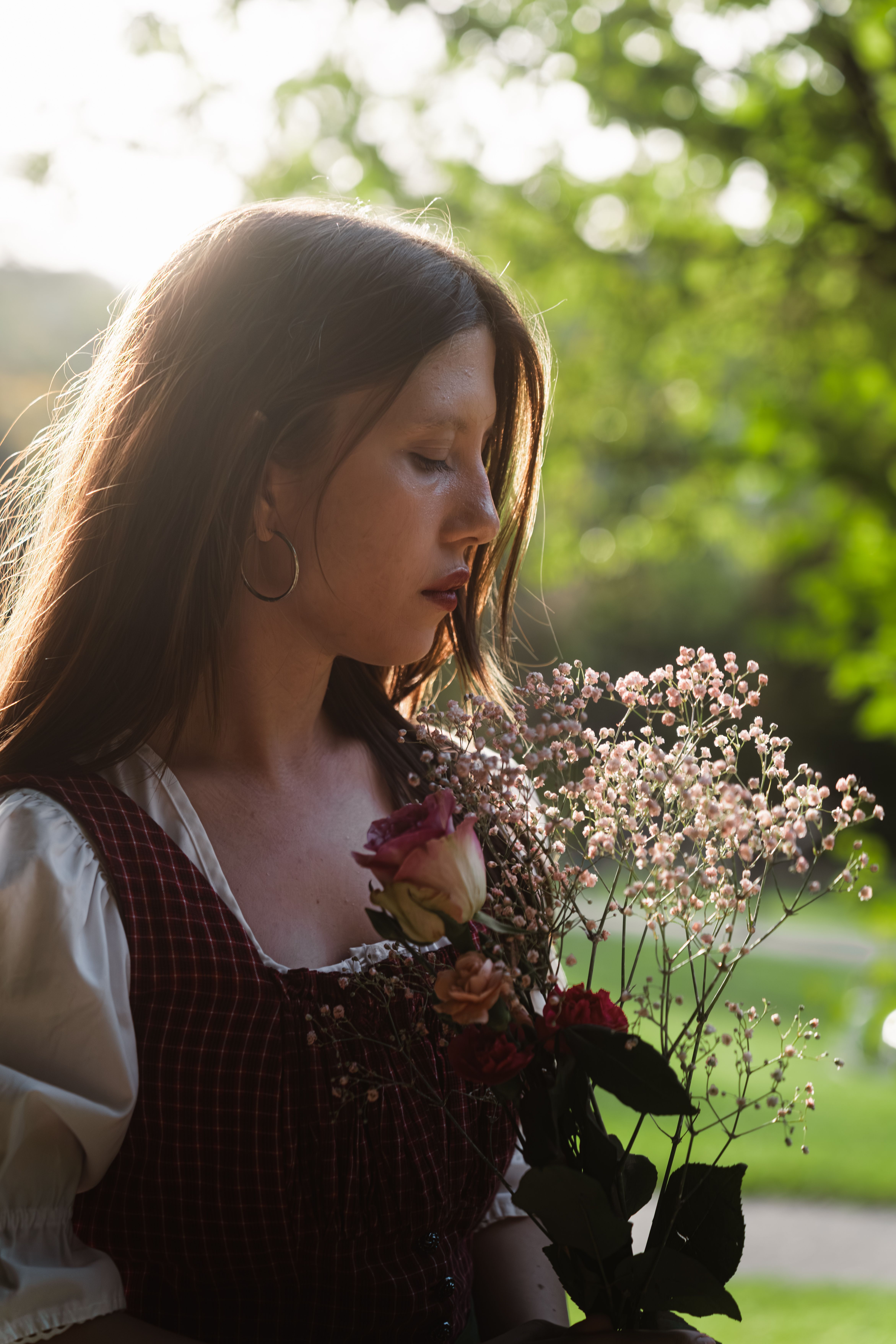 Portrait of a woman in traditional attire holding flowers in Graz, Austria.