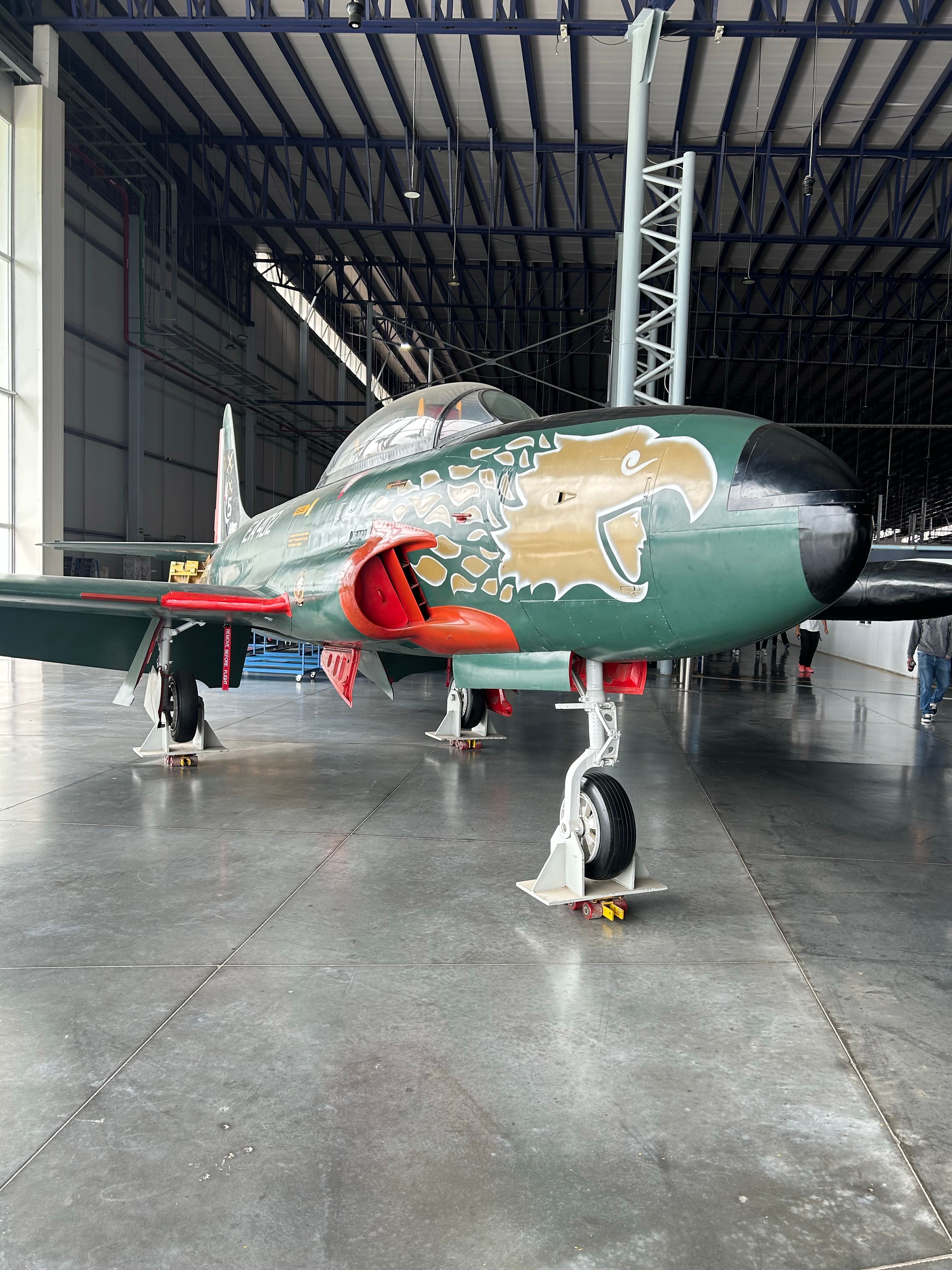 Vintage Military Jet in an Aircraft Hangar · Free Stock Photo