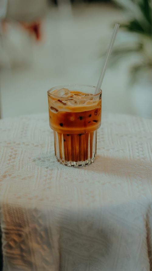 Free A close-up of a glass of iced coffee on a white cloth, perfect for a summer refreshment. Stock Photo