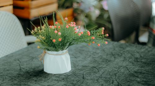 Free Stylish floral arrangement in a geometric vase on a textured table. Stock Photo