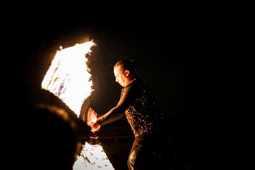 Free Engaging nighttime fire performance with a skilled artist twirling blazing flames under a dark sky. Stock Photo