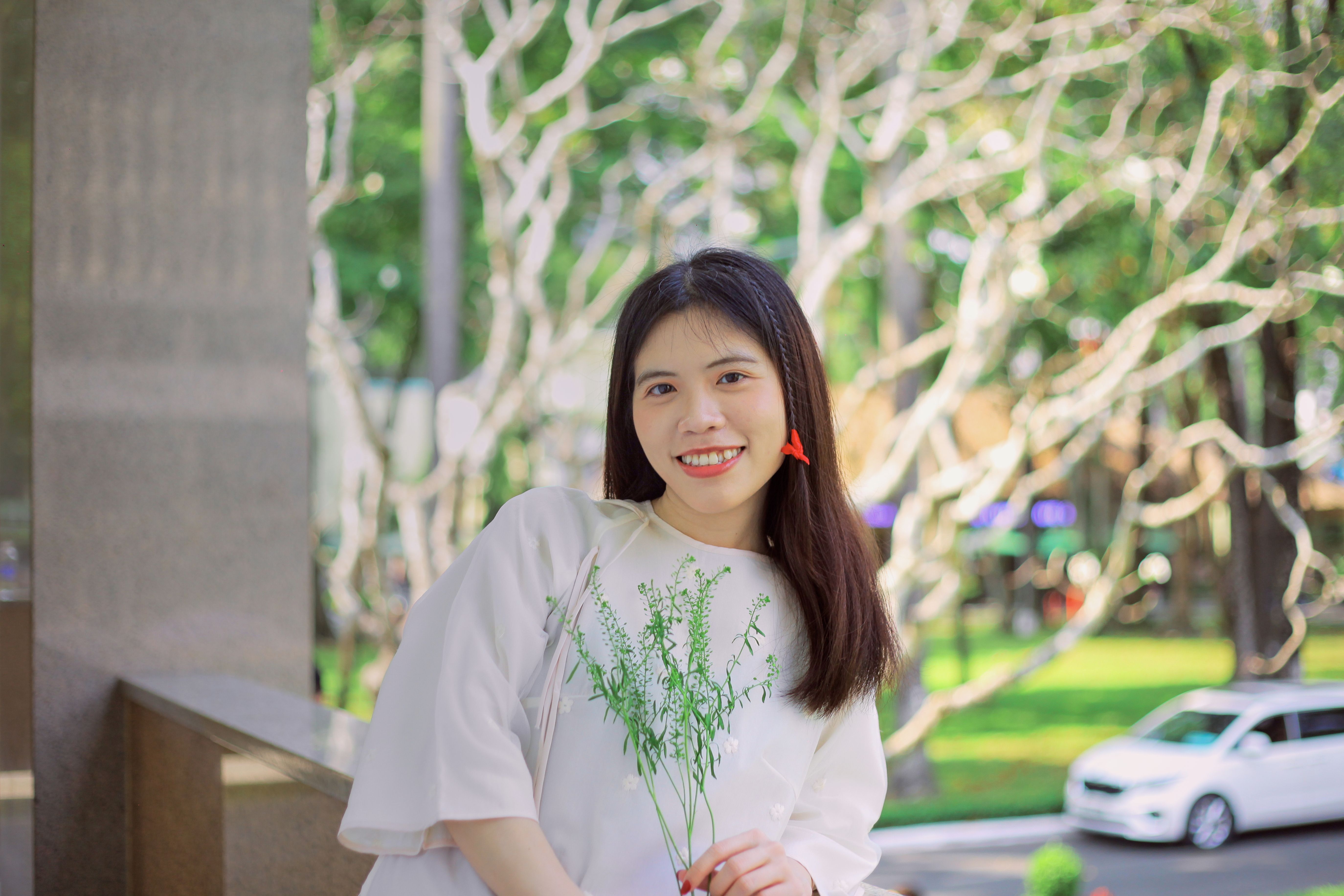 Young Woman Smiling Outdoors with Flowers