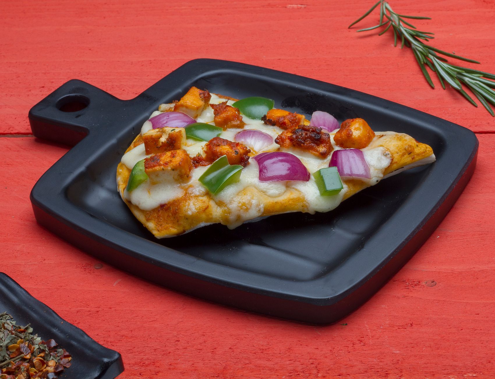 Homemade Indian fusion pizza with paneer and fresh herbs