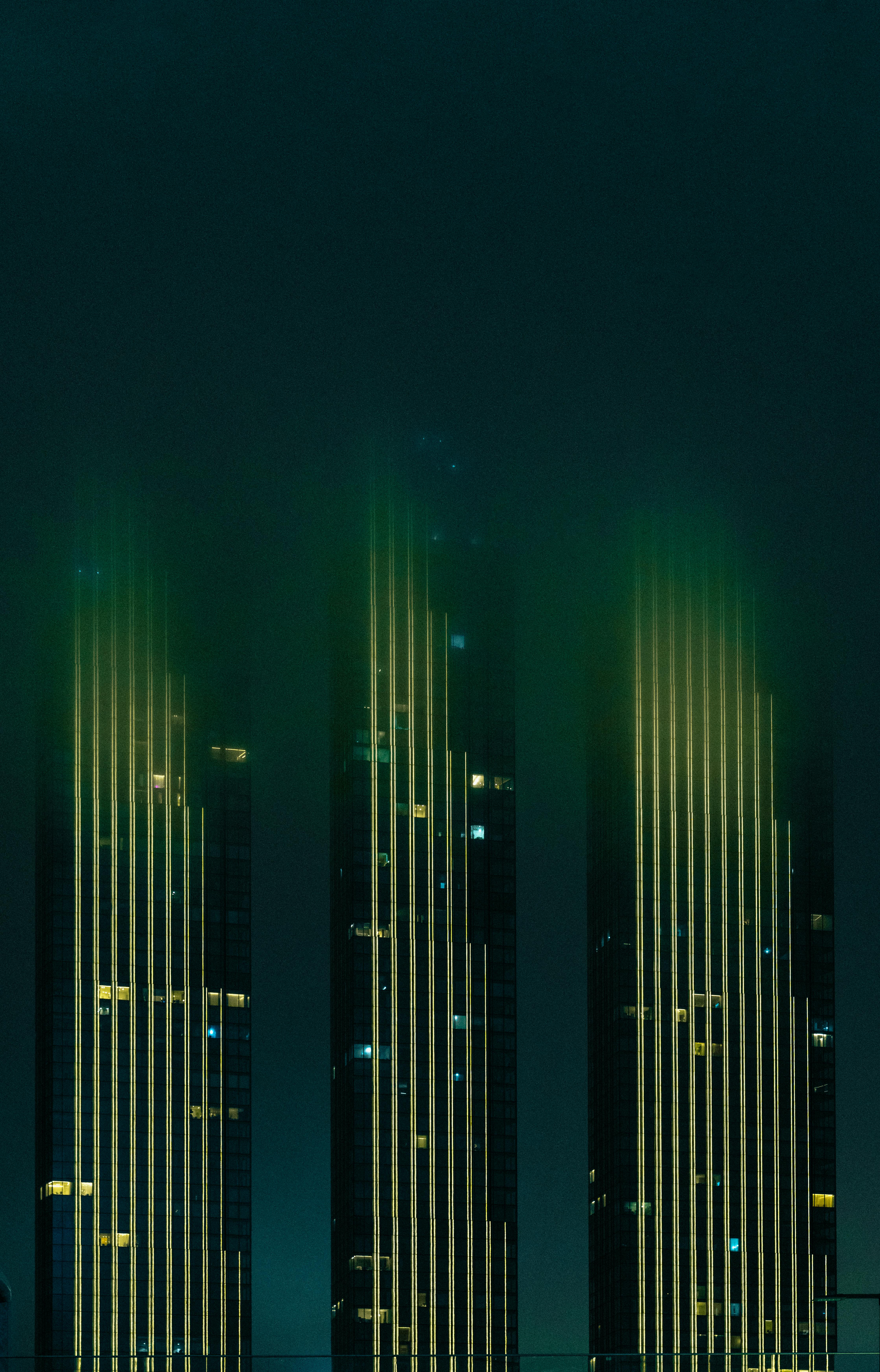 Gratis Grattacieli illuminati di Mosca di notte, che scompaiono nella nebbia, creando un misterioso skyline urbano. Foto a disposizione