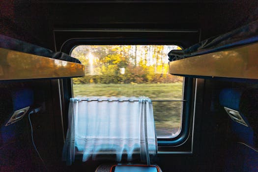 Interior view of a train cabin with autumn landscape outside, creating a serene travel atmosphere.