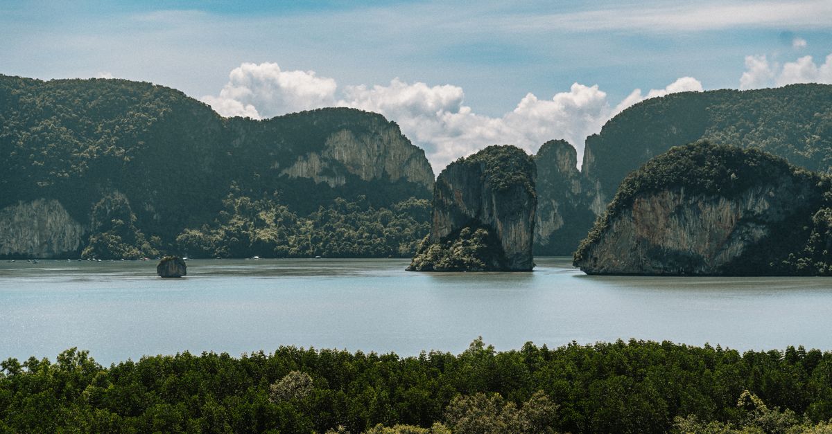 Tranquil view of limestone cliffs and lush greenery in Krabi, Thailand.