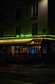 Enchanting night view of a cozy Parisian restaurant with neon lights.