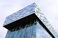 这座现代摩天大楼引人注目，拥有独特的浮动立方体设计和玻璃立面