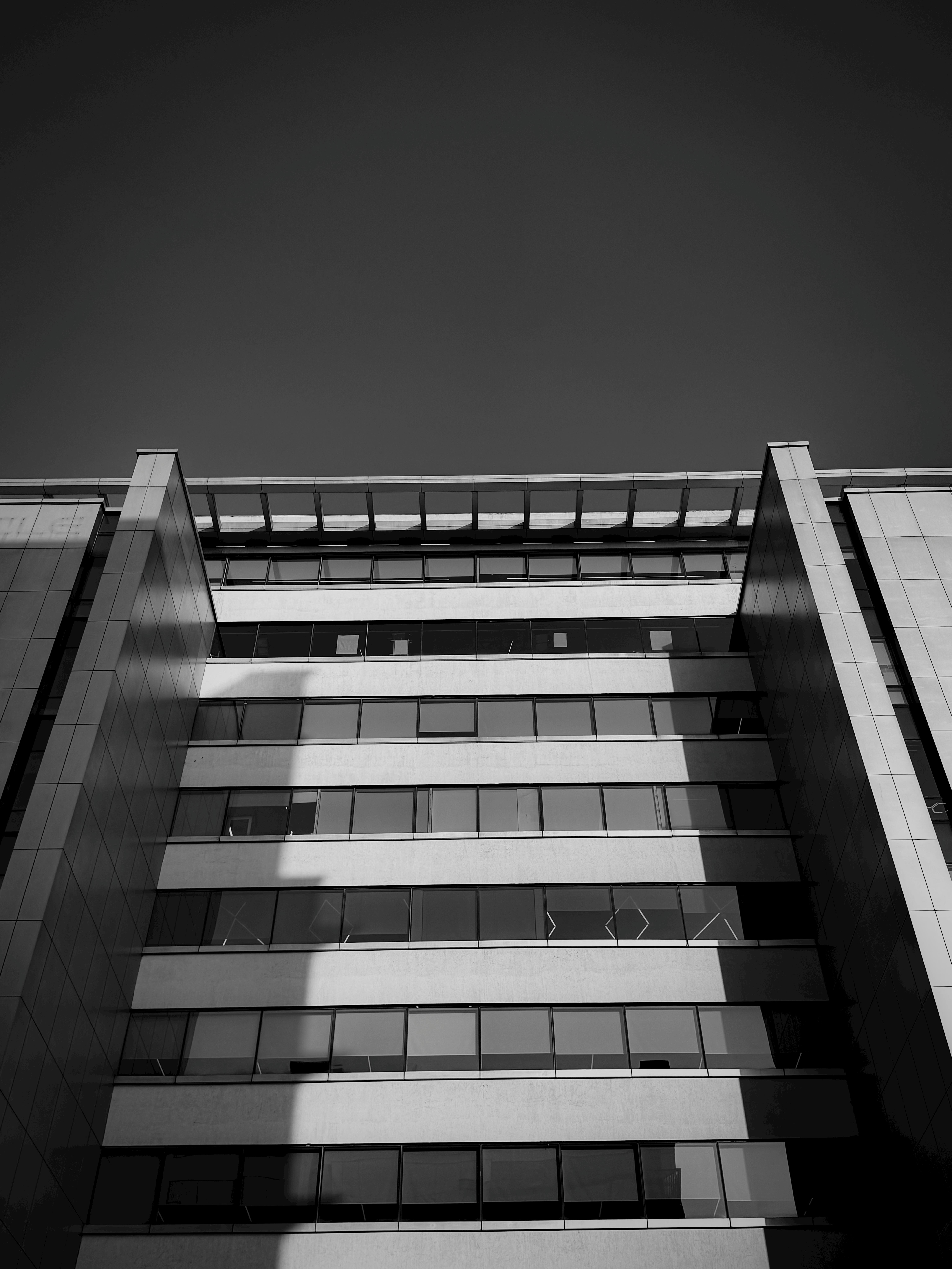 Gratuit Fotografie alb-negru a unei clădiri moderne cu umbre geometrice izbitoare și linii arhitecturale. Fotografie de stoc