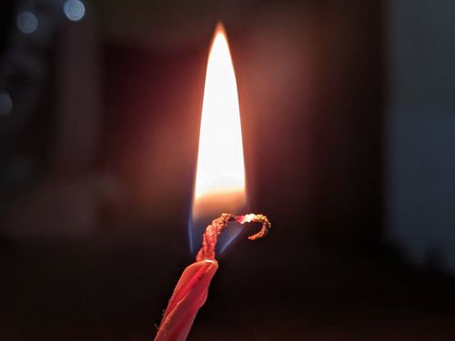 Free A serene, close-up view of a candle flame illuminating the dark. Stock Photo