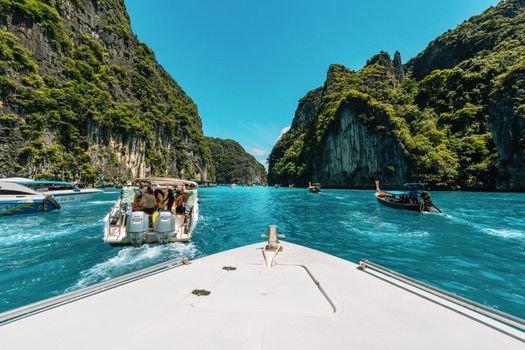Vibrant boat tour through stunning Krabi limestone cliffs in Thailand.
