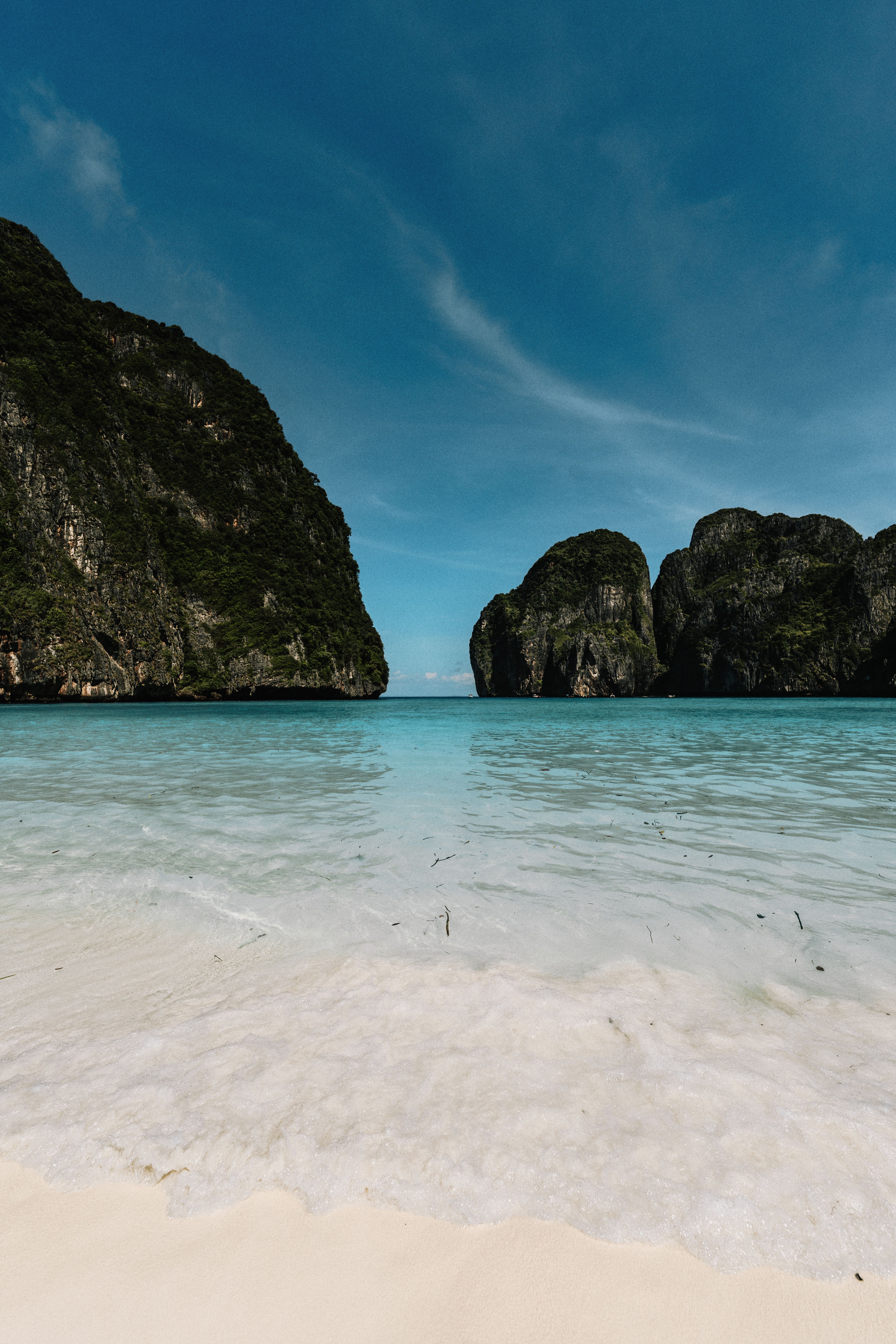 Pristine beach with clear blue waters and lush cliffs in Krabi, Thailand, perfect for travel and nature enthusiasts.