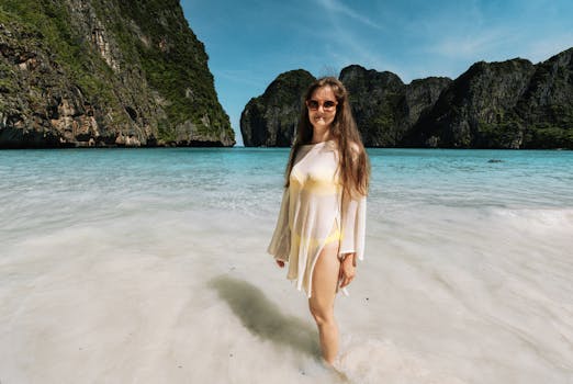 Woman standing in clear waters of Krabi, Thailand with limestone cliffs.