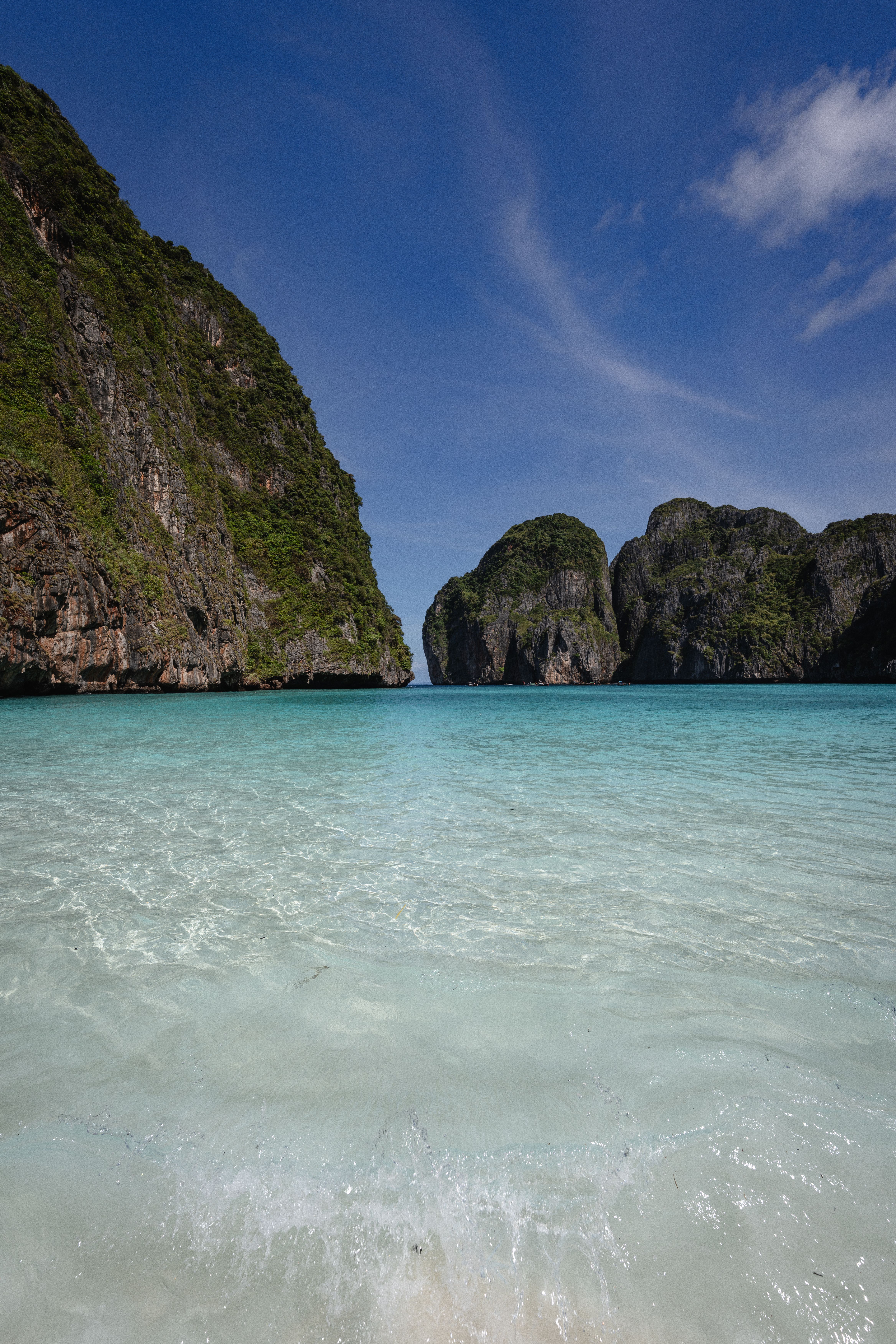 Crystal clear waters and towering cliffs at a pristine beach in Krabi, Thailand create a stunning natural vista.