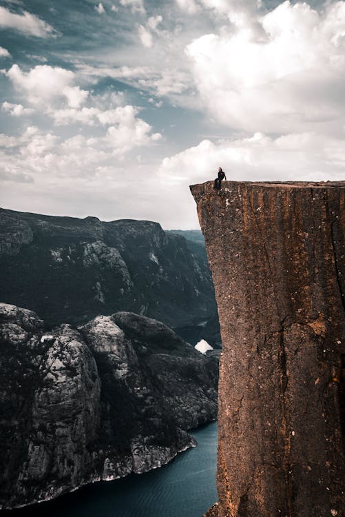Free People Sitting on the Edge of a Cliff Stock Photo