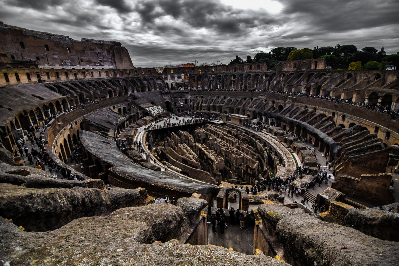 Dramatic aerial view of the ancient Colosseum in Rome, Italy, showcasing its historical architecture.
