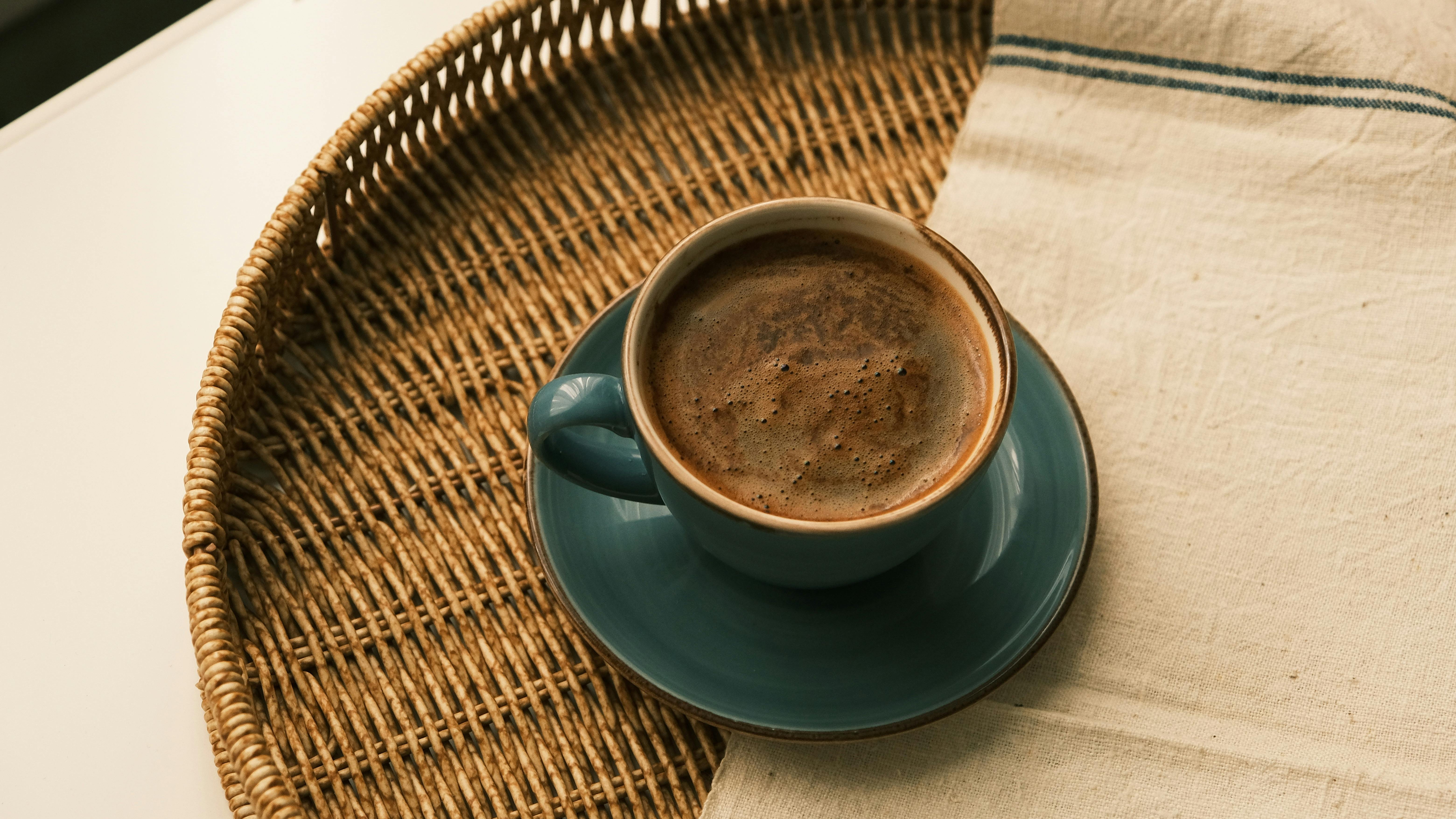 A steaming cup of coffee on a woven tray creates a cozy atmosphere.