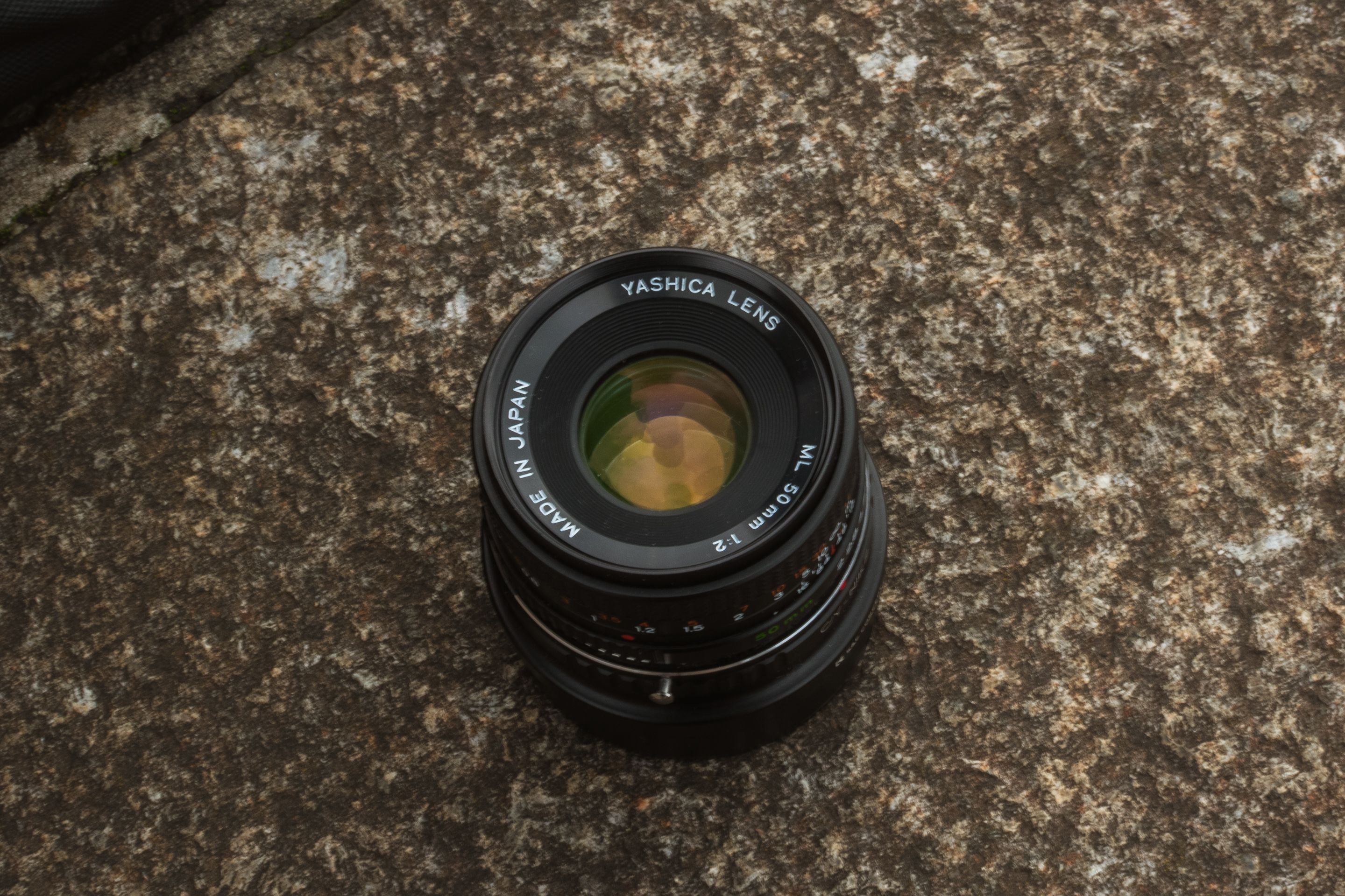 Vintage Yashica Camera Lens on Textured Surface · Free Stock Photo