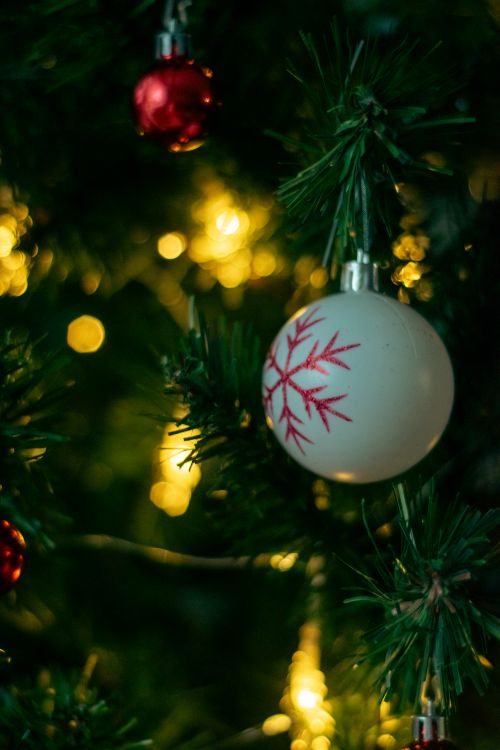 Free Close-up of a Christmas tree decorated with glass ornaments and warm lights. Stock Photo