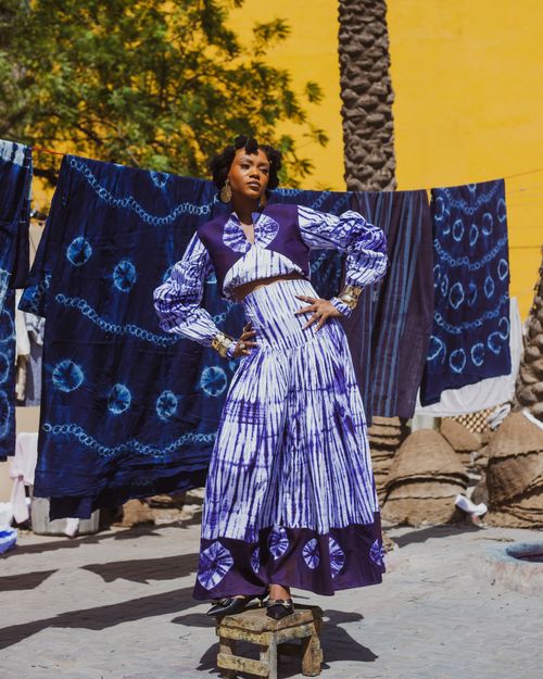 Free Woman in bold tie-dye fashion poses confidently outdoors with vibrant patterns. Stock Photo