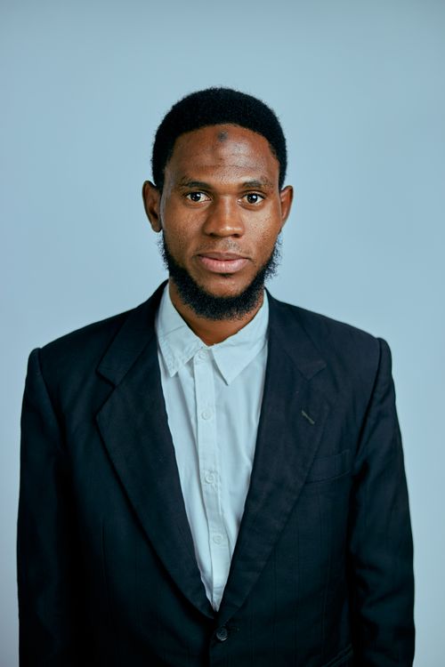 Free Portrait of a man in a suit and shirt against a neutral background, conveying professionalism. Stock Photo
