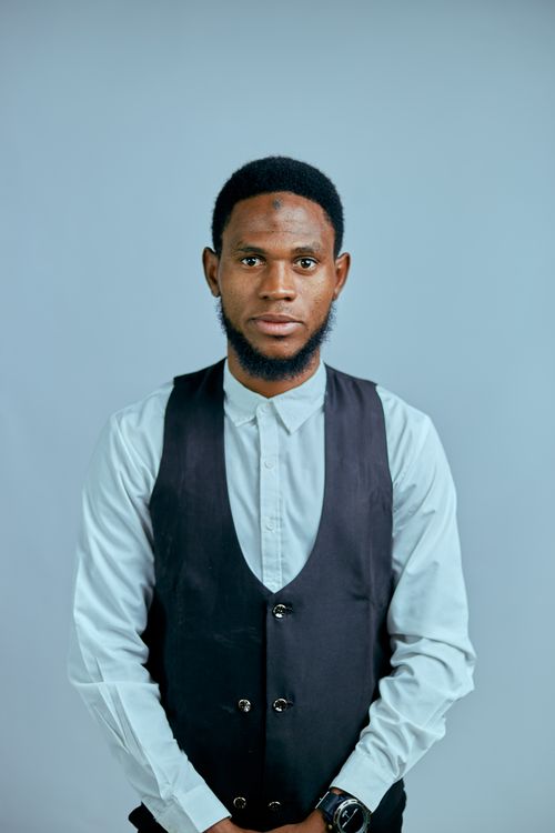 Free Stylish young man in vest posing against a blue background. Stock Photo