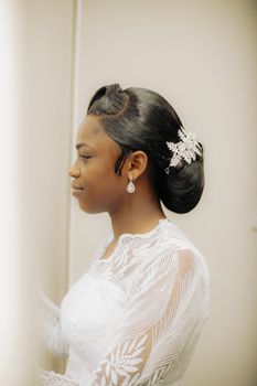 Beautiful bride in elegant lace dress with intricate updo adorned with crystal hairpiece.