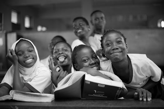 Black and white photo of smiling African students in a classroom environment.