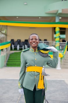 Woman in military dress uniform salutes during a formal ceremony outdoors.