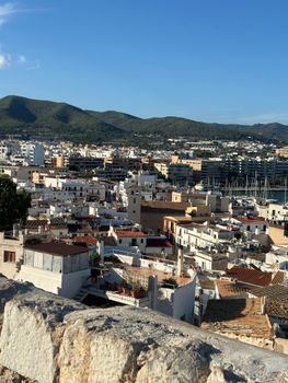 A breathtaking view of Ibiza Town with its historic architecture and marina under a clear blue sky.