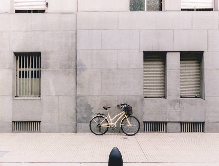 Bicycle Parked Against Concrete Building In