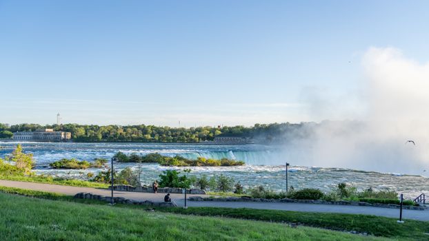 Beautiful view of Niagara Falls with mist and blue sky from the New York side.