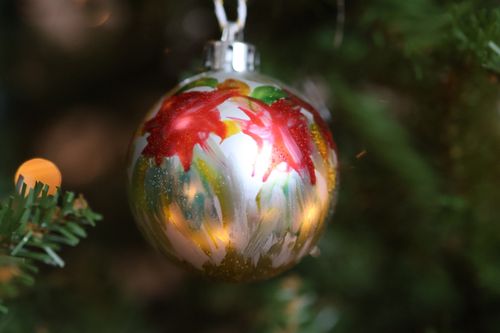 Free Close-up of a hand-painted Christmas ornament hanging on a tree branch. Stock Photo