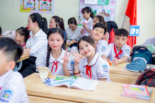 Primary school students seated in a classroom in Hanoi, Vietnam, engaging in learning and interaction.