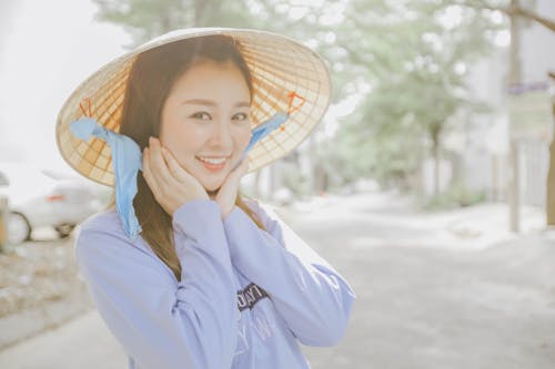 Smiling Woman Touching Her Face Wearing Hat