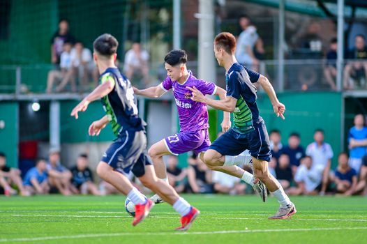 Dynamic action shot of a youth soccer game in Hà Nội, capturing players competing for the ball.