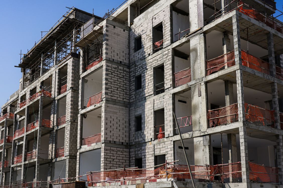 Modern multifamily apartment development under construction with scaffolding