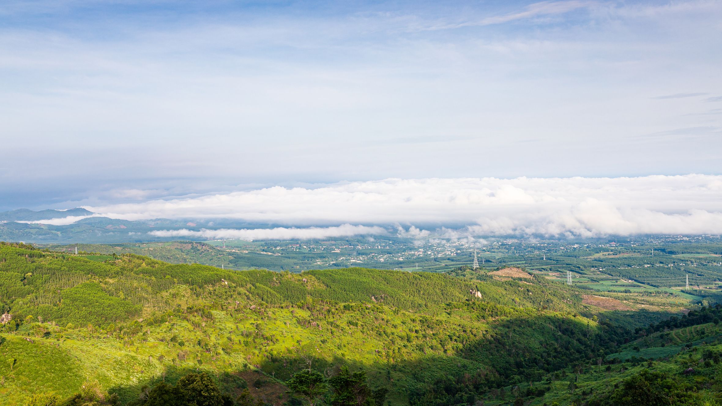 A breathtaking view of green hills and clouds in Kon Tum, Vietnam, showcasing natural beauty.