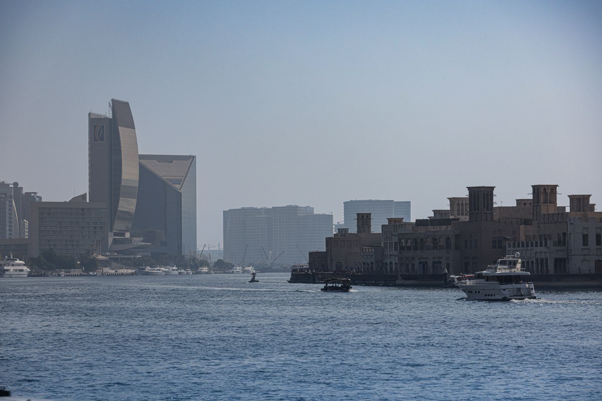 Gulf waterfront with traditional boats and modern buildings representing Gulf markets