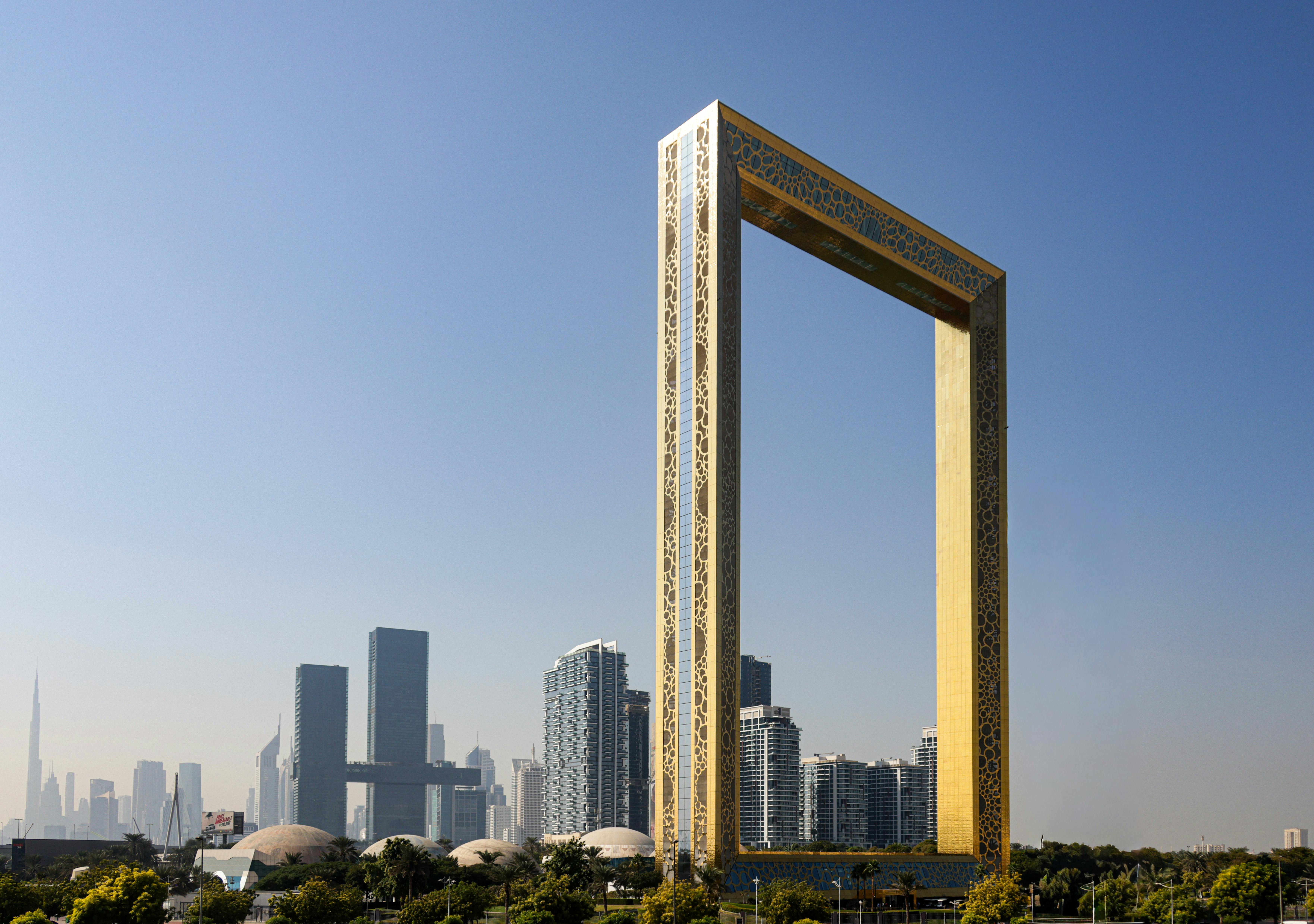 The iconic Dubai Frame with city skyscrapers in the background under a clear sky.