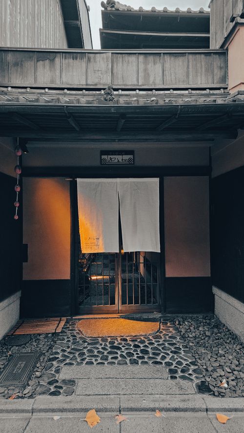 Free A serene entrance of a Japanese building with a traditional noren curtain at twilight. Stock Photo