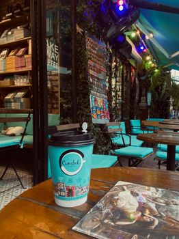 Inviting street café scene with takeaway coffee and art book. Perfect for relaxation.