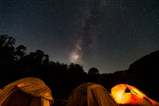 Captivating night camping scene in India with starry sky and glowing tents under the Milky Way.
