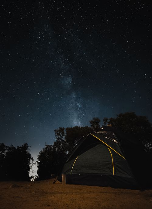 Free A serene campsite under a star-filled sky with the Milky Way visible. Stock Photo