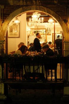 Warm ambiance of an Italian restaurant with people enjoying dinner under soft lighting.