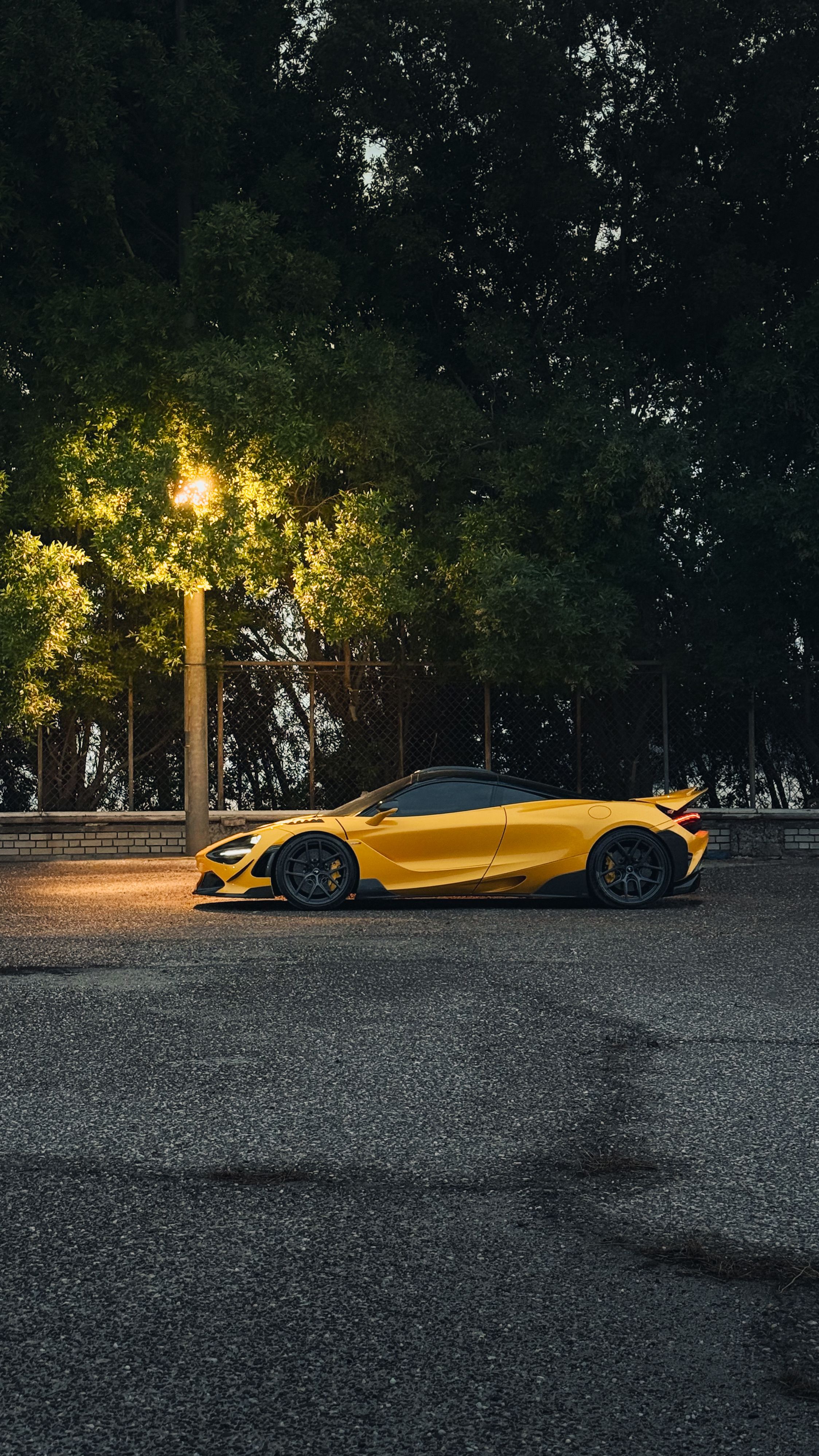 Sleek Yellow Sports Car under Streetlight at Dusk · Free Stock Photo