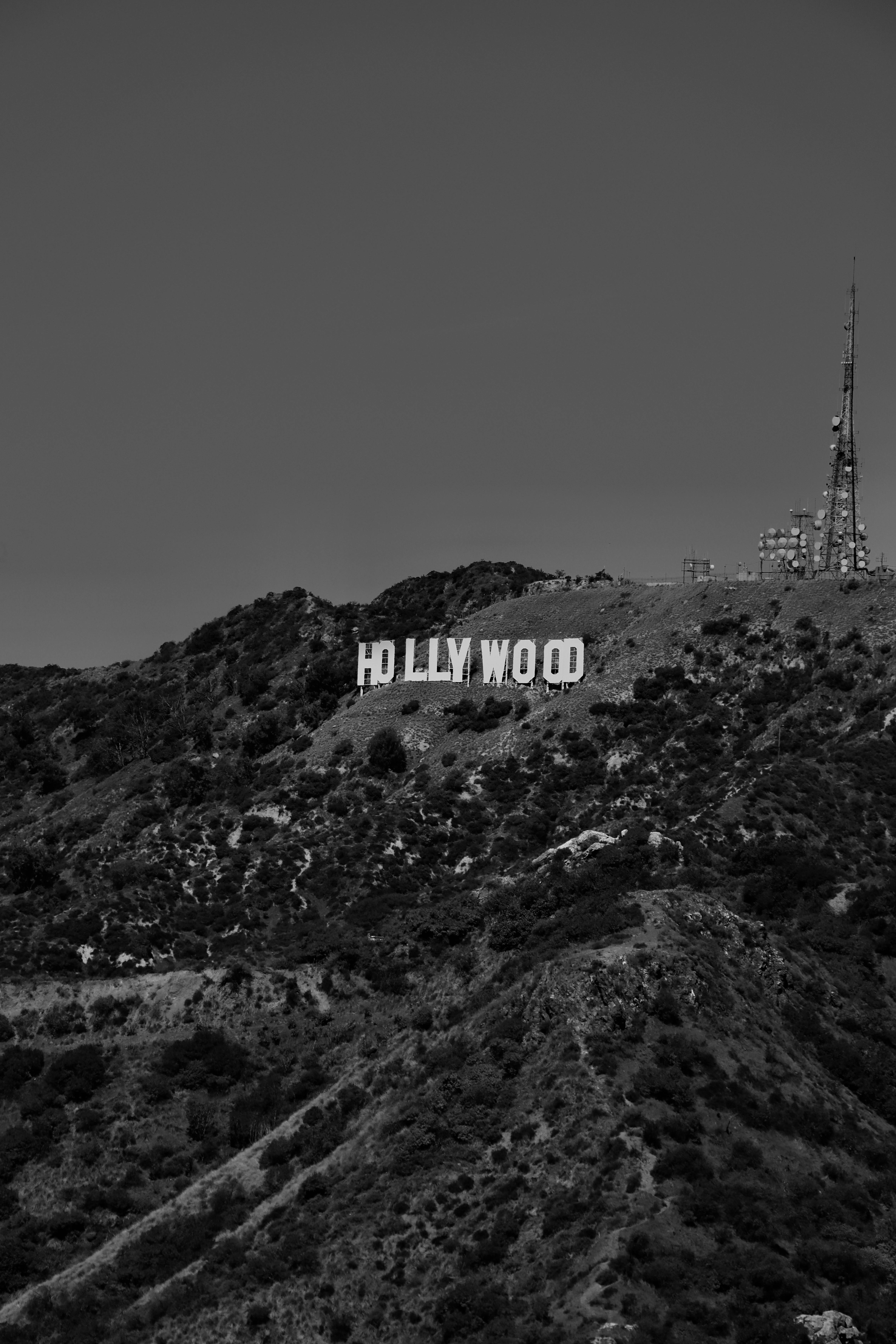 A black and white photo of the Hollywood sign located in the hills of Los Angeles, California.